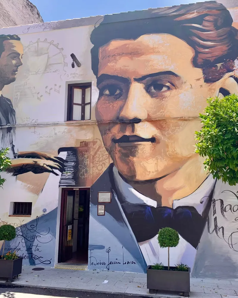 Mural de Federico García Lorca en una fachada de Granada, con su retrato y versos manuscritos