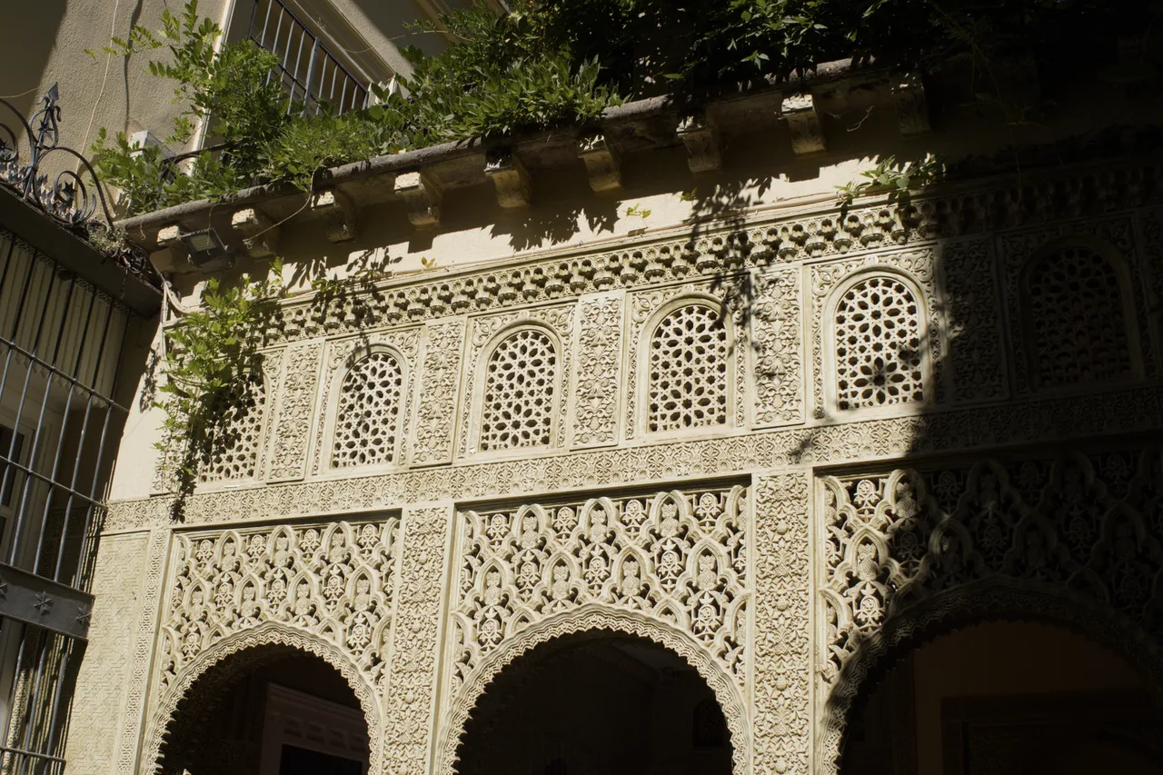 Arcos y yeserías nazaríes con celosías en los Palacios Nazaríes de la Alhambra