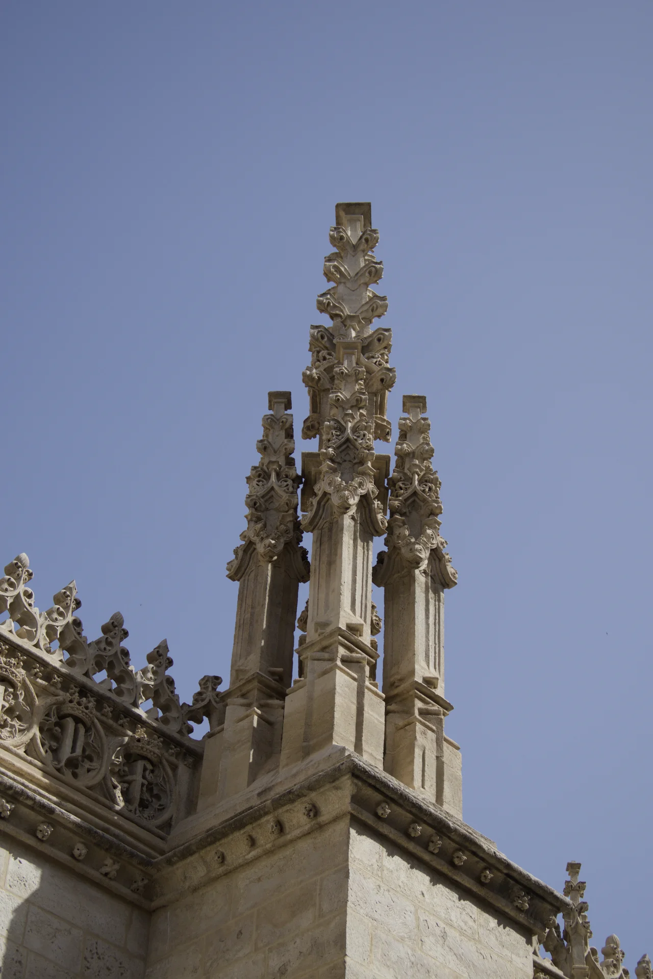Gothic architectural detail with crocketed pinnacles against a blue sky in central Granada
